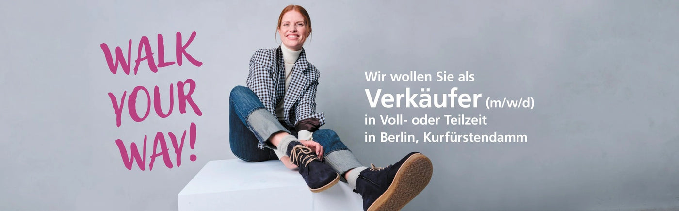 Frau in modischer Kleidung sitzt auf einer Box mit der Aufschrift 'Walk Your Way', Stellenanzeige für Verkäufer (m/w/d) in Berlin, Kurfürstendamm in Voll- oder Teilzeit