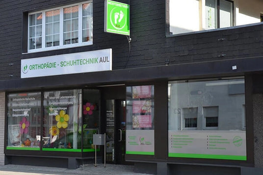Außenansicht des Geschäfts Orthopädieschuhtechnik Aul mit Schaufenstern und grünem Firmenschild